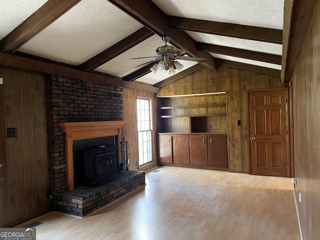 3021 Tiffin Cir, Macon, GA 31204 - unfurnished living room with light wood finished floors, wood walls, vaulted ceiling with beams, a textured ceiling, and ceiling fan