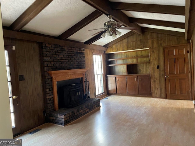 3021 Tiffin Cir, Macon, GA 31204 - unfurnished living room featuring a ceiling fan, vaulted ceiling with beams, wooden walls, and light wood-style flooring