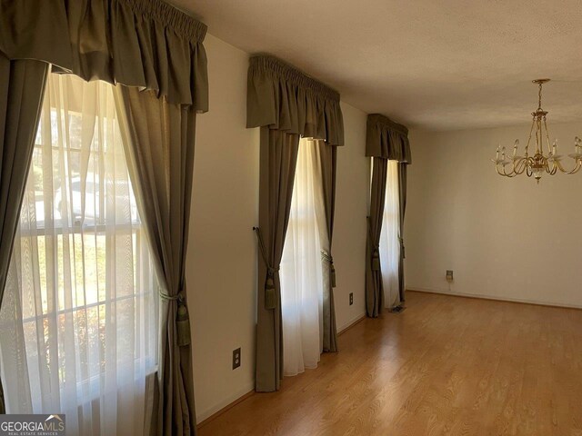 3021 Tiffin Cir, Macon, GA 31204 - unfurnished room with light wood finished floors and a notable chandelier