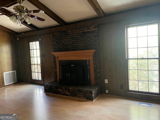 3021 Tiffin Cir, Macon, GA 31204 - unfurnished living room featuring wood walls, wood finished floors, beam ceiling, and visible vents