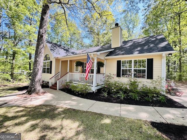 single story home with a chimney and covered porch