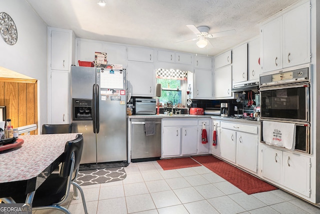 1292 Marcelle Heights Pl NW, Norcross, GA 30093 - kitchen with appliances with stainless steel finishes, ceiling fan, white cabinets, a sink, and backsplash