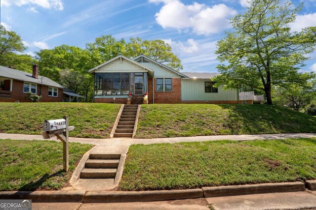 5 Seventh St, Gainesville, GA 30504 - view of front facade with a front lawn, a sunroom, and stairs