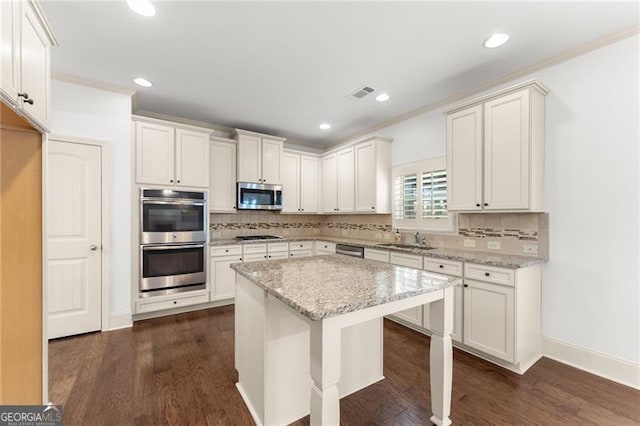 kitchen with dark wood-type flooring, decorative backsplash, visible vents, and stainless steel appliances
