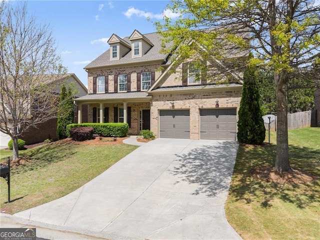 view of front of house with an attached garage, fence, brick siding, a front lawn, and driveway