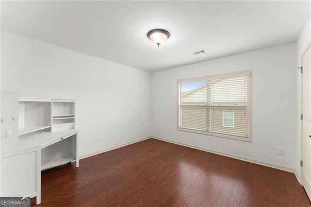 interior space featuring baseboards, dark wood finished floors, and visible vents