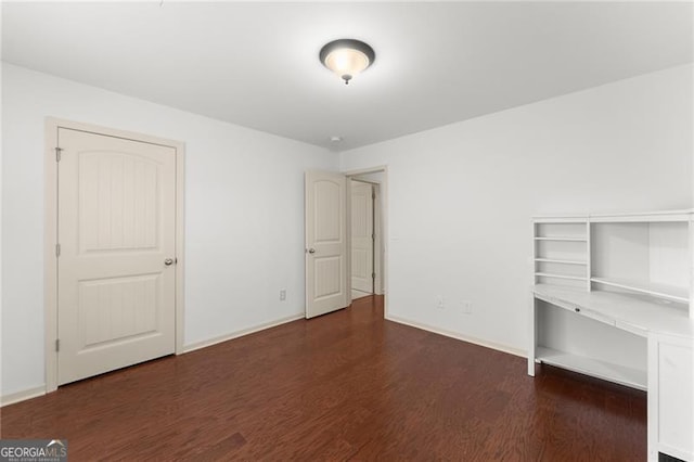 unfurnished bedroom featuring wood finished floors and baseboards