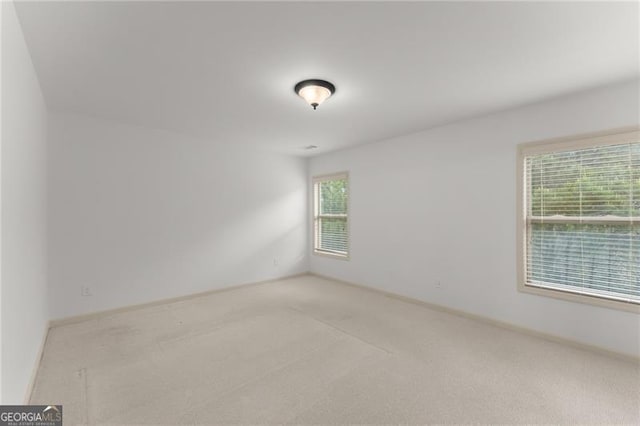 unfurnished room with carpet floors and baseboards
