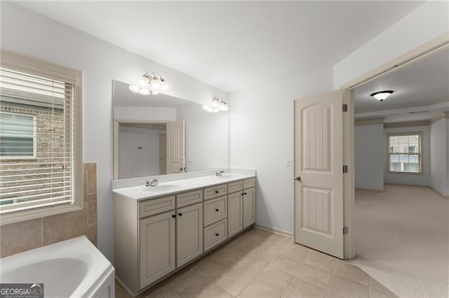 bathroom with a sink, tile patterned floors, double vanity, and a garden tub