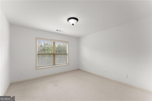 empty room with visible vents, baseboards, and carpet flooring