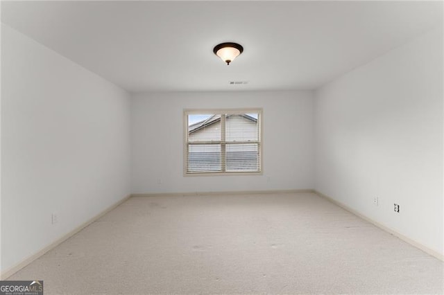 spare room featuring visible vents, baseboards, and carpet