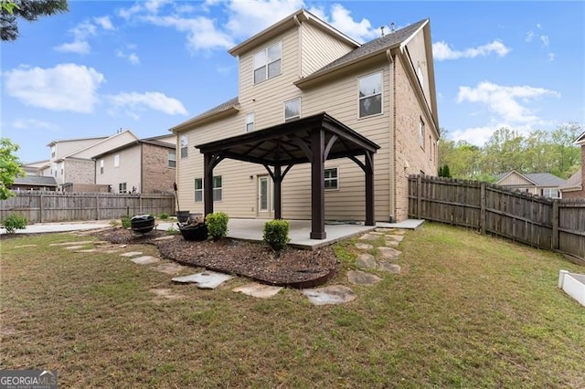 rear view of property featuring a gazebo, a patio area, a fenced backyard, and a lawn