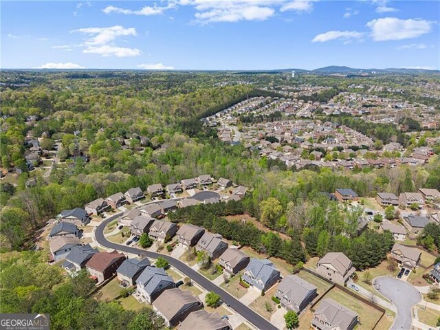 drone / aerial view with a wooded view and a residential view