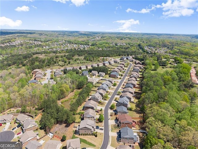 aerial view featuring a wooded view and a residential view