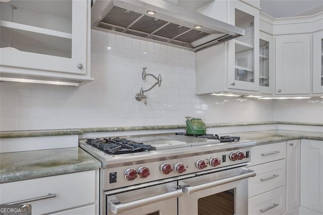 934 Pine Cir, Woodstock, GA 30189 - kitchen featuring white cabinetry, wall chimney range hood, backsplash, and double oven range