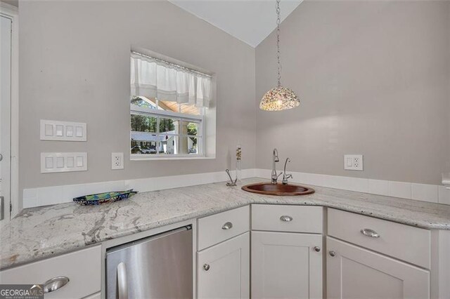 934 Pine Cir, Woodstock, GA 30189 - kitchen with vaulted ceiling, light stone counters, white cabinets, a sink, and hanging light fixtures