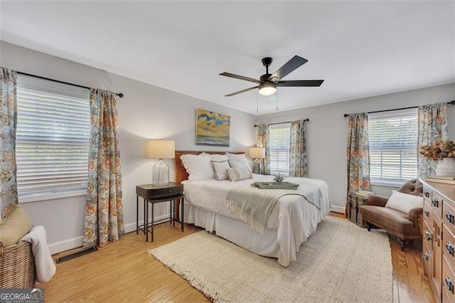 934 Pine Cir, Woodstock, GA 30189 - bedroom with light wood finished floors, visible vents, baseboards, and a ceiling fan