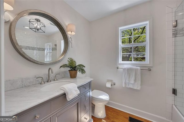 934 Pine Cir, Woodstock, GA 30189 - full bathroom featuring vanity, toilet, a chandelier, wood finished floors, and baseboards