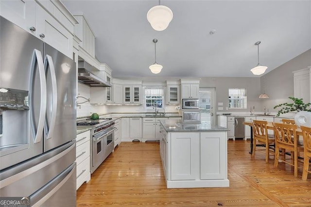 934 Pine Cir, Woodstock, GA 30189 - kitchen featuring stainless steel appliances, white cabinets, a healthy amount of sunlight, and wall chimney range hood