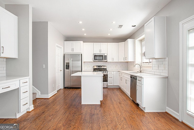 4609 Mctyre Way NW, Marietta, GA 30064 - kitchen featuring appliances with stainless steel finishes, decorative backsplash, wood finished floors, recessed lighting, and a kitchen island