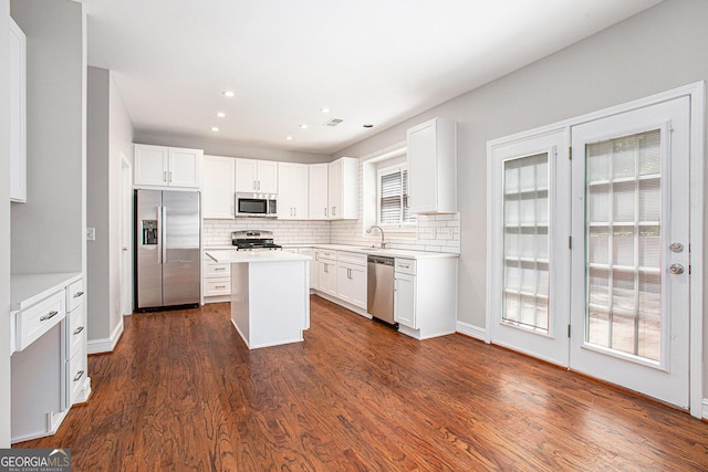 4609 Mctyre Way NW, Marietta, GA 30064 - kitchen with appliances with stainless steel finishes, backsplash, a center island, dark wood finished floors, and recessed lighting