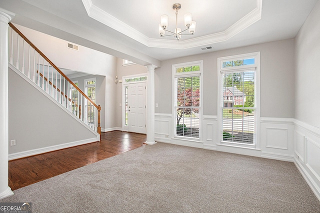 4609 Mctyre Way NW, Marietta, GA 30064 - carpeted foyer entrance featuring ornate columns, ornamental molding, stairs, a tray ceiling, and a chandelier