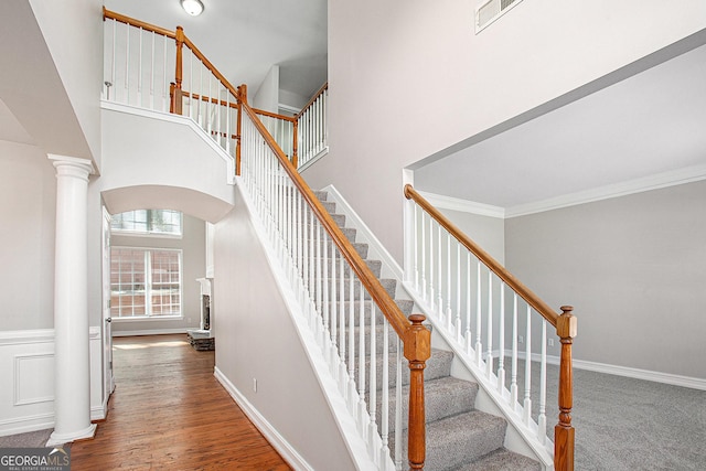 4609 Mctyre Way NW, Marietta, GA 30064 - staircase featuring arched walkways, a towering ceiling, wood finished floors, crown molding, and decorative columns