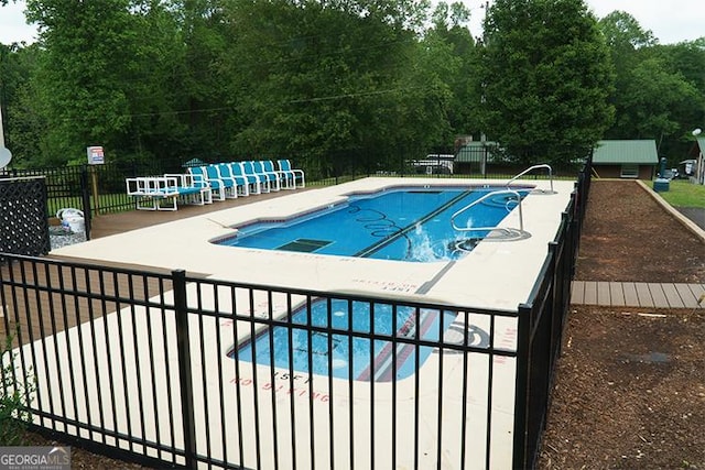 community pool featuring a patio and fence