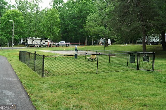surrounding community with fence and a yard