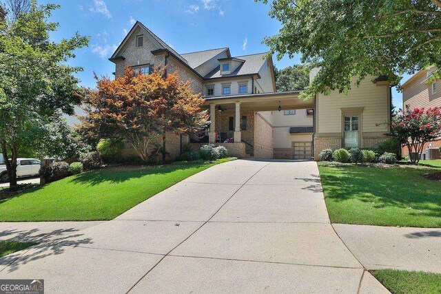 view of front of home with a front yard, driveway, and brick siding