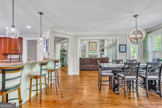 dining room with recessed lighting, ornamental molding, light wood-type flooring, and a chandelier