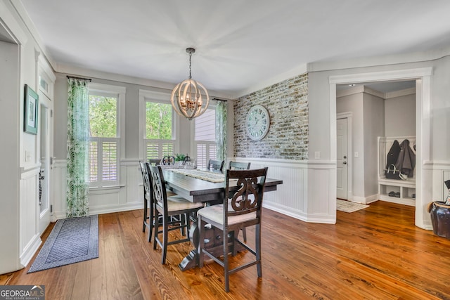 dining room with a decorative wall, a notable chandelier, and hardwood / wood-style floors