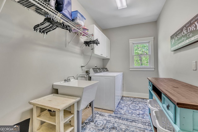laundry area with baseboards, cabinet space, light tile patterned floors, and washer and dryer