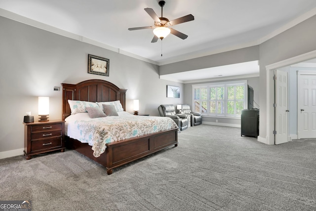carpeted bedroom with crown molding, baseboards, and a ceiling fan
