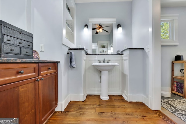 bathroom featuring a ceiling fan, baseboards, and wood finished floors