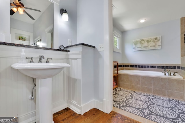 full bathroom featuring a sink, ceiling fan, and a garden tub
