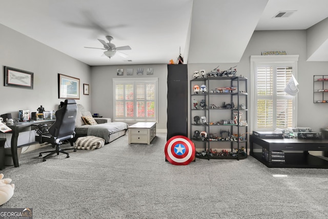 interior space featuring plenty of natural light, ceiling fan, carpet, and visible vents