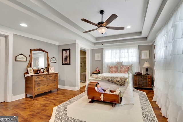 bedroom featuring recessed lighting, wood finished floors, and a raised ceiling