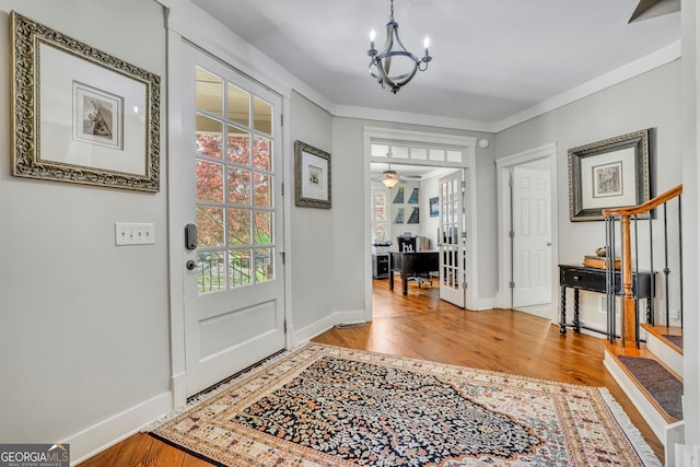 foyer featuring baseboards, wood finished floors, and a notable chandelier
