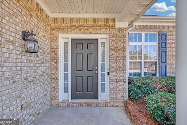 view of exterior entry with brick siding
