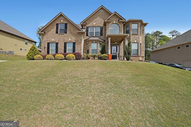 view of front of property featuring a front yard, central AC unit, and brick siding