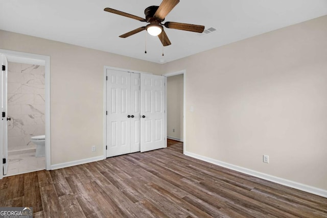 930 Burney Branch Cir, Blackshear, GA 31516 - unfurnished bedroom featuring visible vents, baseboards, a closet, ensuite bath, and wood finished floors