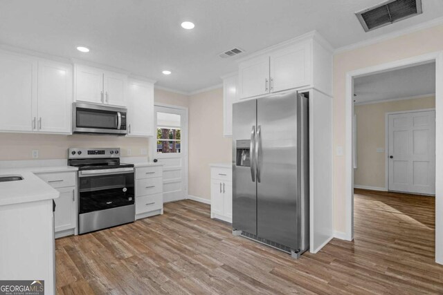 930 Burney Branch Cir, Blackshear, GA 31516 - kitchen with stainless steel appliances, visible vents, ornamental molding, and light wood-style flooring