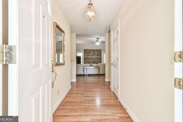 hallway featuring light wood-style floors and baseboards