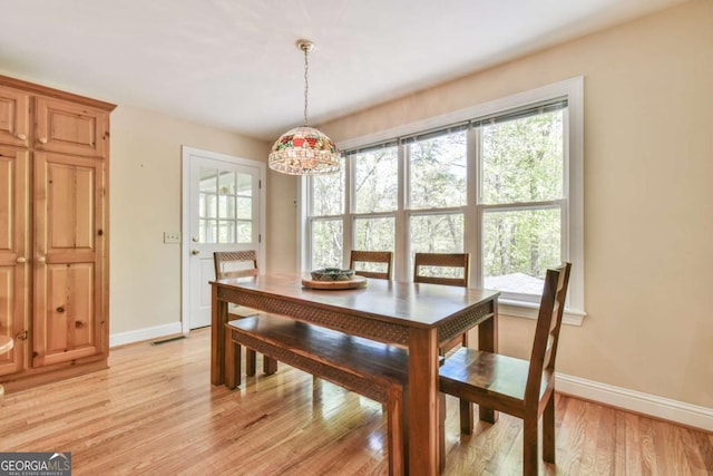 dining room featuring light wood-style flooring and baseboards