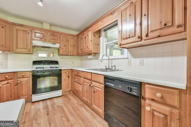kitchen with range with gas cooktop, dishwasher, a sink, light wood-style floors, and under cabinet range hood