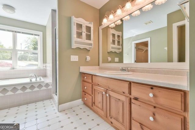 bathroom featuring a shower with door, vanity, baseboards, a bath, and visible vents