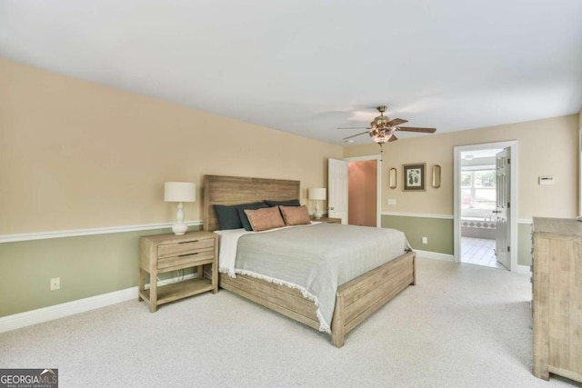 bedroom with carpet flooring, baseboards, a ceiling fan, and ensuite bath