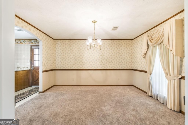 2237 W Elm St, Wrightsville, GA 31096 - empty room featuring light colored carpet, arched walkways, a chandelier, and ornamental molding