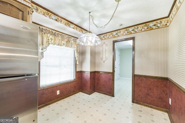 2237 W Elm St, Wrightsville, GA 31096 - unfurnished dining area with wallpapered walls, tile patterned floors, crown molding, baseboards, and wainscoting